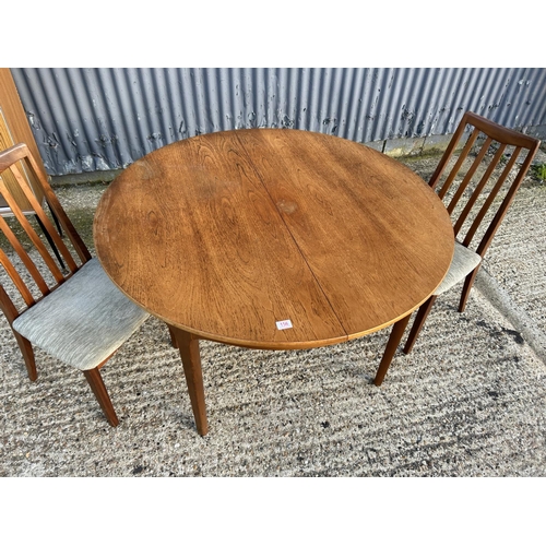 156 - Nathan teak circular dining table together with 2 G plan teak dining chairs