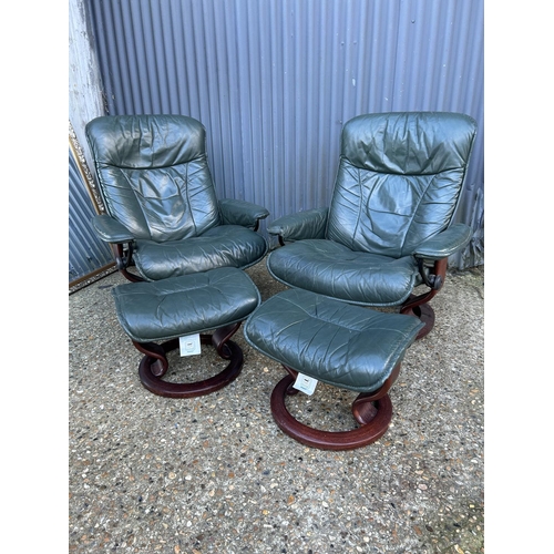 164 - A pair of green leather Ekornes stressless reclining chairs with footstools