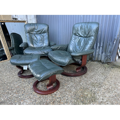 164 - A pair of green leather Ekornes stressless reclining chairs with footstools