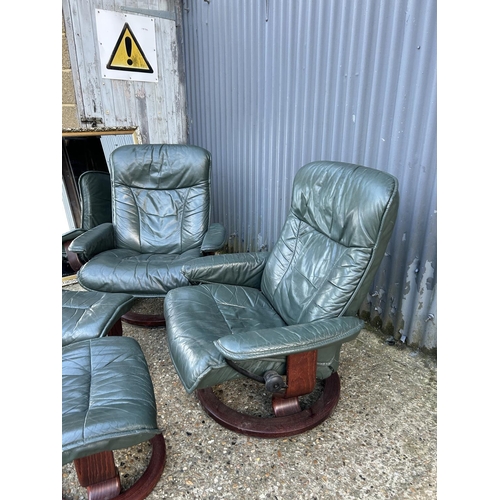 164 - A pair of green leather Ekornes stressless reclining chairs with footstools