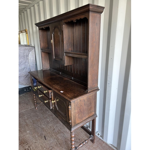 354 - An oak dresser, having plate rack top over two drawer and two door base