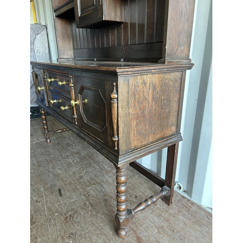 354 - An oak dresser, having plate rack top over two drawer and two door base