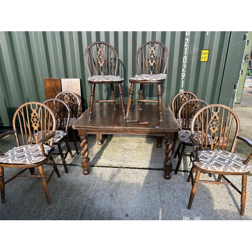 355 - Oak wind out dining table with two extension leaves together with a set of 8 wheel back dining chair... 