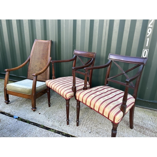 358 - An oak framed begere bedroom chair together with a pair of mahogany carver chairs