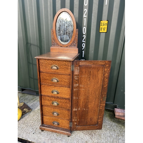 359 - An early 20th century oak chest of six drawers, enclosed with a single door and with mirror back