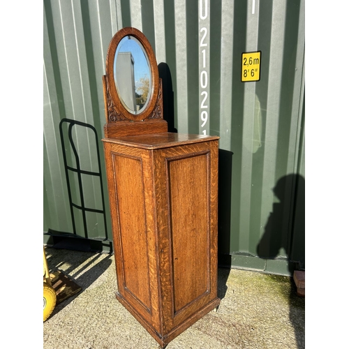 359 - An early 20th century oak chest of six drawers, enclosed with a single door and with mirror back