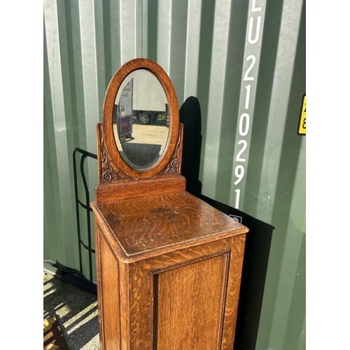 359 - An early 20th century oak chest of six drawers, enclosed with a single door and with mirror back