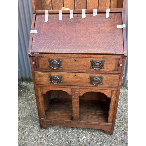 4 - An arts and crafts oak bureau bookcase with glazed top over shelves and two drawers