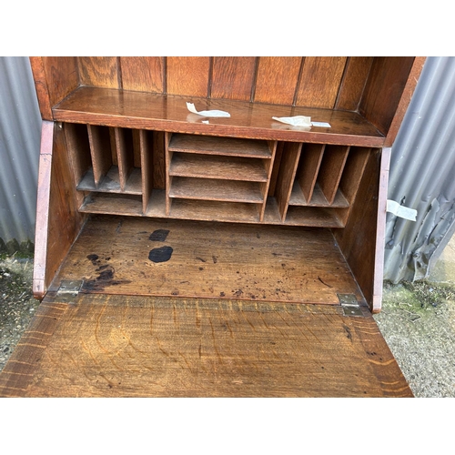 4 - An arts and crafts oak bureau bookcase with glazed top over shelves and two drawers