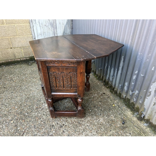 5 - A carved oak hall table with telescopic leg extending to support a fold over top