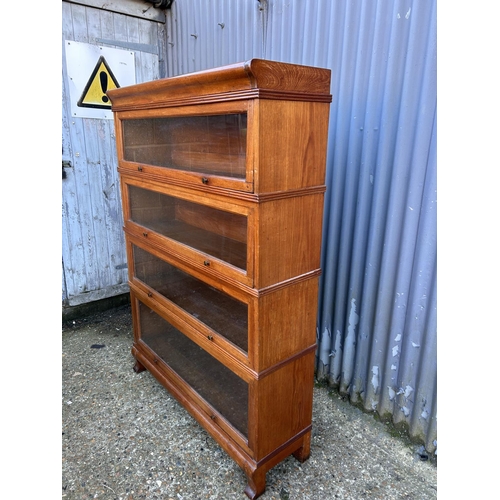 54 - An early 20th century oak four section stacking bookcase with up and over glazed doors 107x30x152