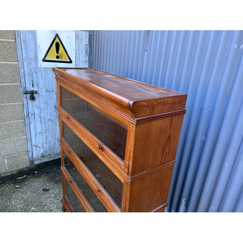 54 - An early 20th century oak four section stacking bookcase with up and over glazed doors 107x30x152