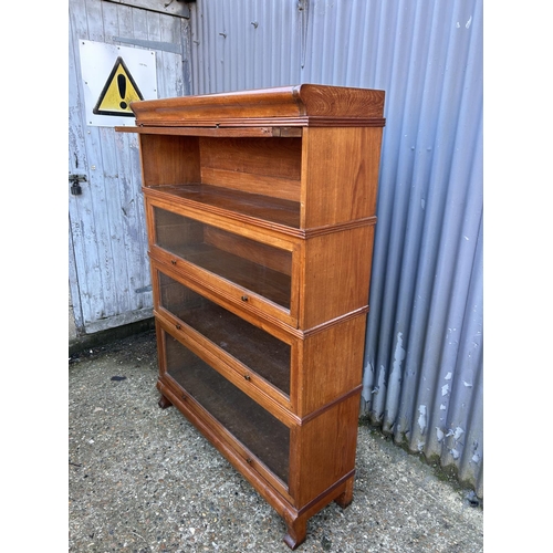 54 - An early 20th century oak four section stacking bookcase with up and over glazed doors 107x30x152