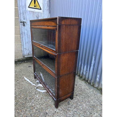 63 - A 20th century globe wernicke style oak three section stacking bookcase with up and over doors 87x31... 