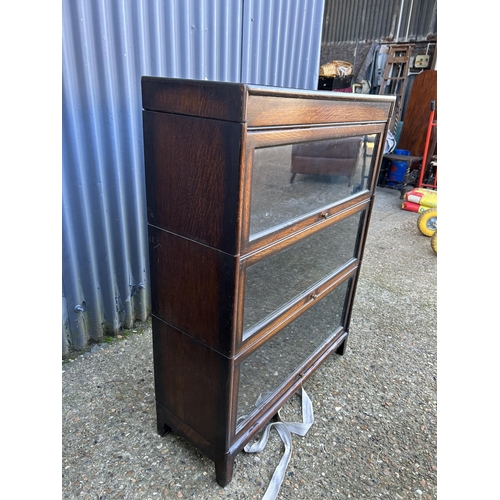 63 - A 20th century globe wernicke style oak three section stacking bookcase with up and over doors 87x31... 