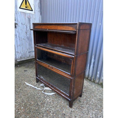 63 - A 20th century globe wernicke style oak three section stacking bookcase with up and over doors 87x31... 