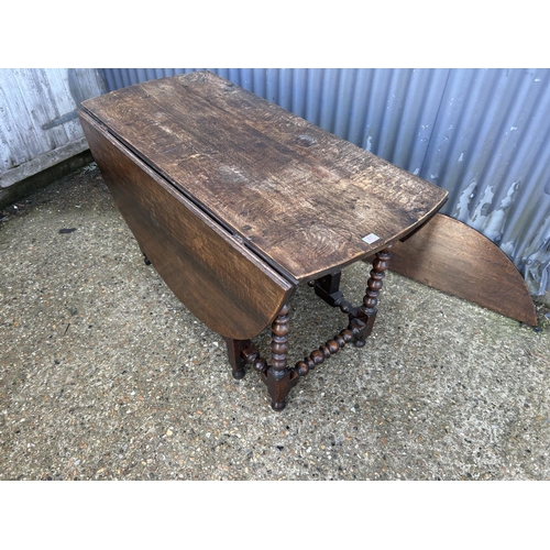 67 - A large antique oak gateleg table with drawer