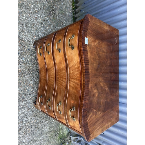 8 - A reproduction mahogany serpentine chest of four drawers