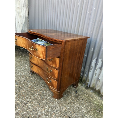 8 - A reproduction mahogany serpentine chest of four drawers