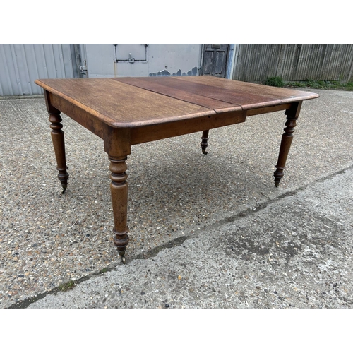108 - A Victorian mahogany extending dining table with two extension leaves 142x102 max size