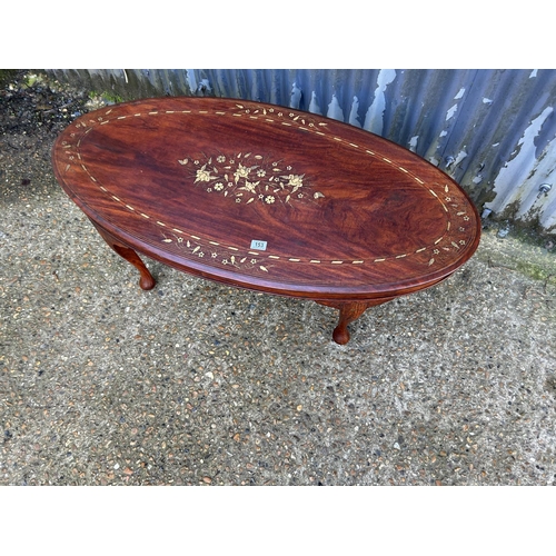 153 - An eastern rosewood oval coffee table with brass inlay