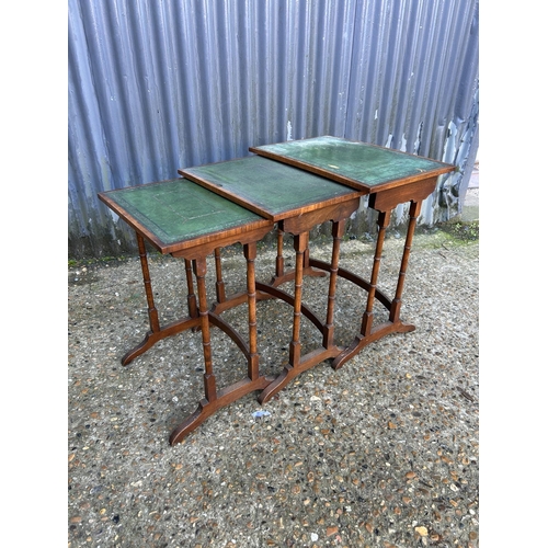 165 - A reproduction mahogany nest of three tables with green leather tops