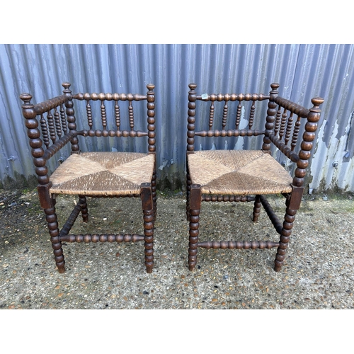 166 - A pair of bobbin oak corner chairs with rush seats