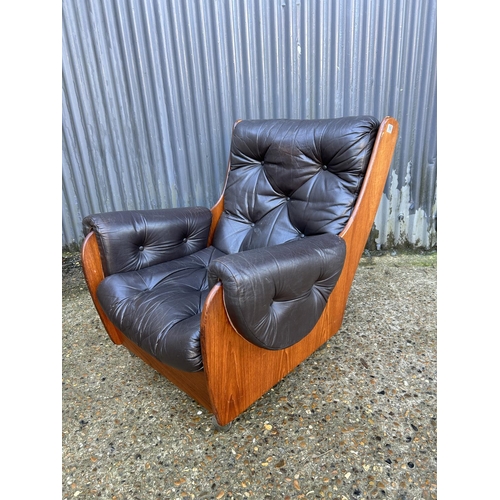 169 - A retro g plan teak framed armchair with brown leather seat