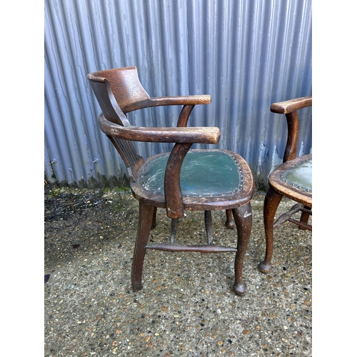 172 - A pair of 20th century oak desk chairs with green leather seats