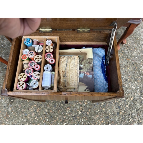 213 - An oak sewing box with contents together with a oak bedide and a modern nest of three tables and a k... 