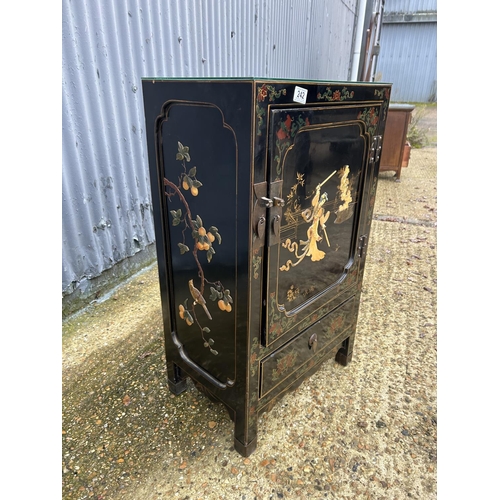 242 - An oriental black laquered single door cupboard 52x34x88