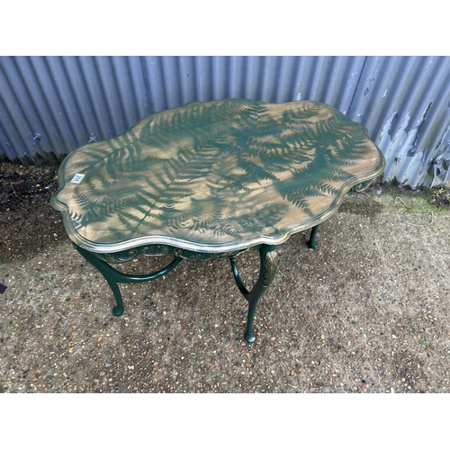 254 - A green and gold painted fern pattern occasional table. 107 x 72 x 72 cms tall