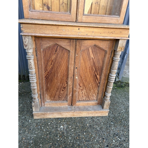 41 - A continental pine bookcase cupboard with a glazed top over two door cupboard base 100x45x227