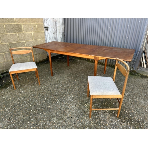 61 - A Mcintsoh teak two leaf extending dining table together with two chairs