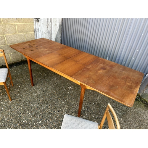61 - A Mcintsoh teak two leaf extending dining table together with two chairs