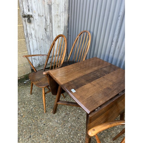 187 - A dark ercol drop leaf dining table together with four ercol stick back chairs