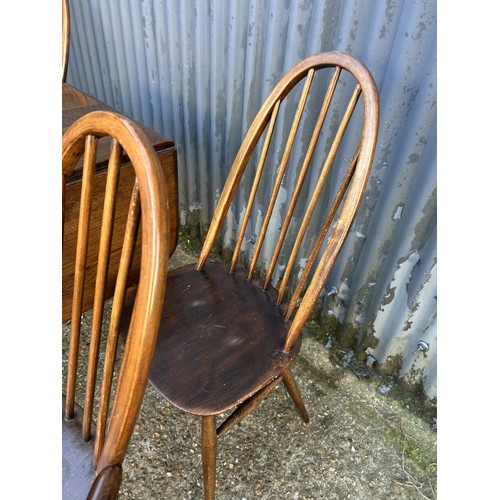 187 - A dark ercol drop leaf dining table together with four ercol stick back chairs