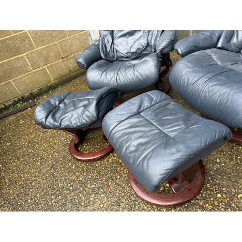 101 - A pair of EKORNES stressless blue leather reclining chairs with stools