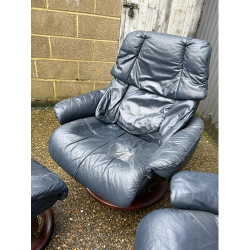 101 - A pair of EKORNES stressless blue leather reclining chairs with stools