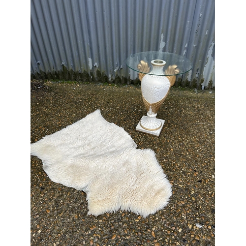 114 - A glass top side table and sheepskin rug