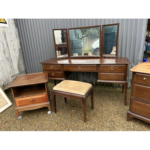 204 - A suite of stag minstrel bedroom furniture including dressing table, stool, chest of three and a bed... 