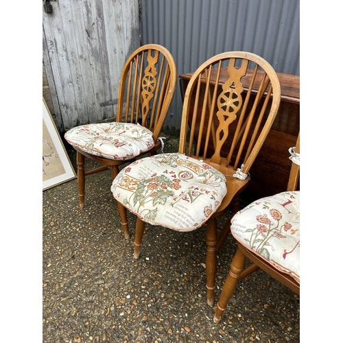 210 - An oak gateleg table together with four wheelback dining chairs