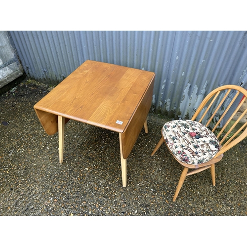 23 - An Ercol light elm drop leaf kitchen table and one chair