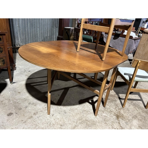 28 - A retro light oak drop leaf table with four chairs