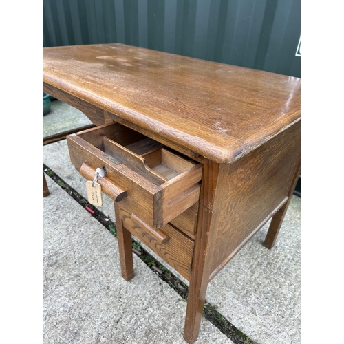 281 - A vintage oak three drawer typist desk 121x69x77