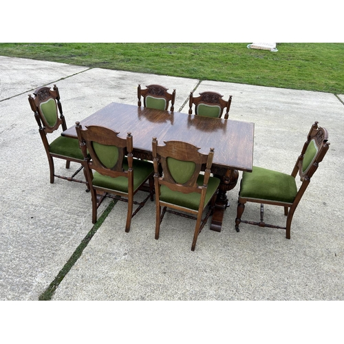 289 - A good quality extending oak dining table together with a set of six Edwardian green upholstered din... 