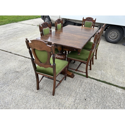 289 - A good quality extending oak dining table together with a set of six Edwardian green upholstered din... 