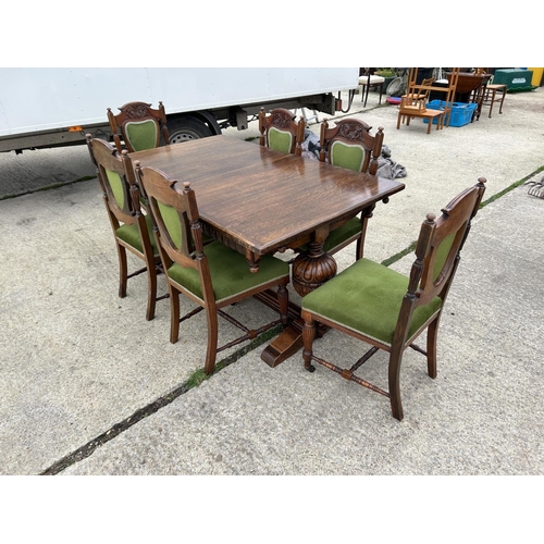 289 - A good quality extending oak dining table together with a set of six Edwardian green upholstered din... 