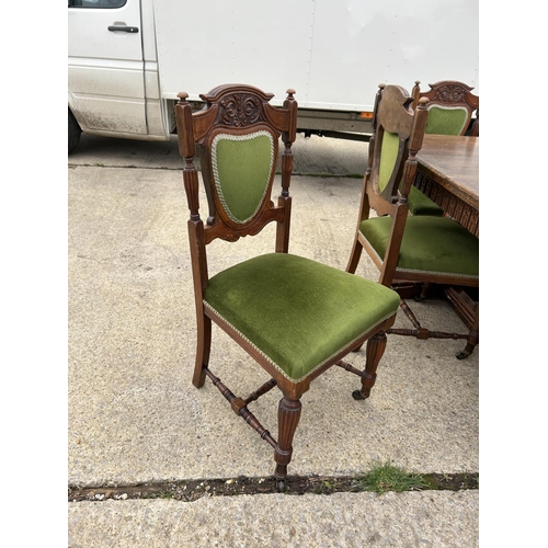 289 - A good quality extending oak dining table together with a set of six Edwardian green upholstered din... 