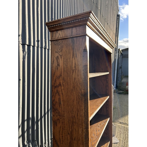 3 - A tall reproduction oak open fronted bookcase 207x30x100